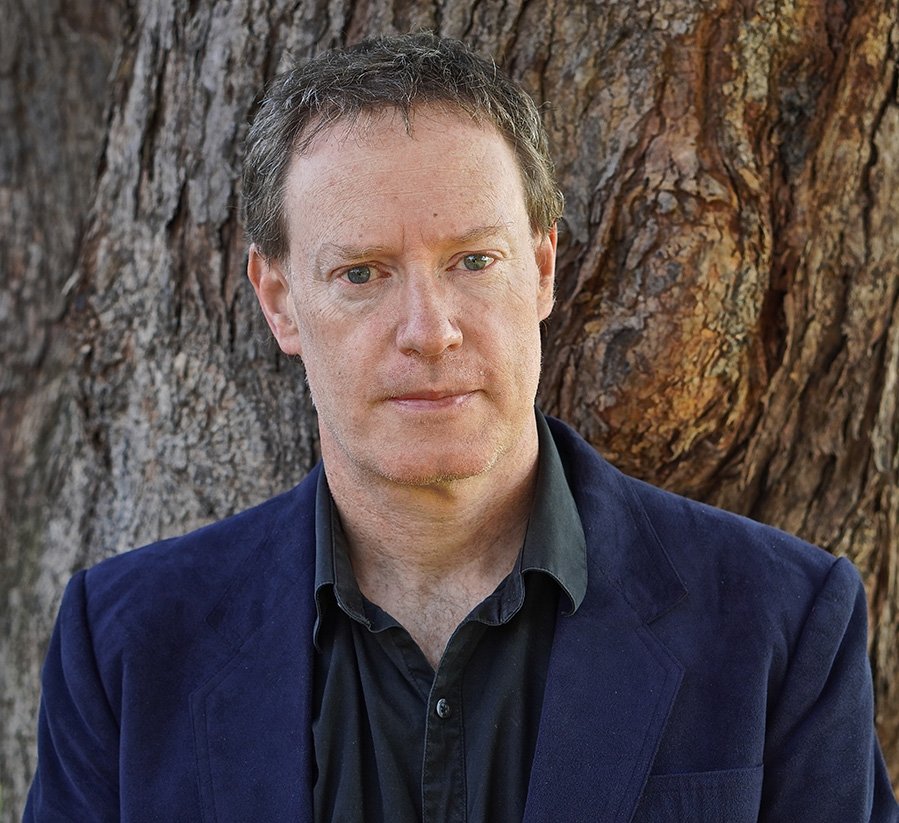 Matt McMahon, headshot against tree trunk